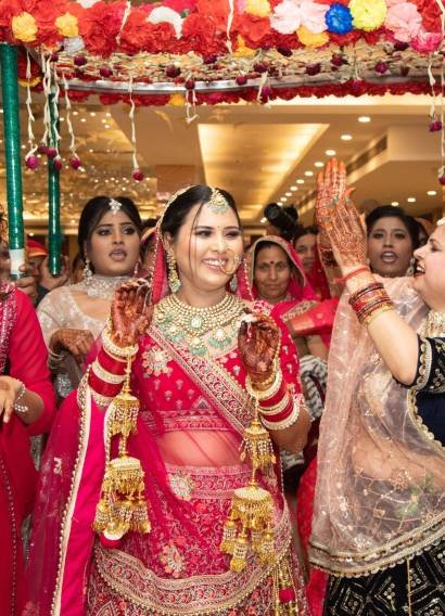 A joyful Indian wedding with a bride and guests in traditional attire, dancing and smiling